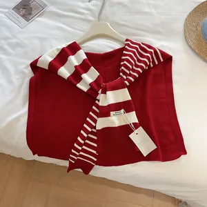 Detail eines rot gestreiften Strickschal-Kragens mit MILLDI-Markenetikett auf Stoff