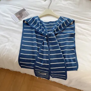 Gros plan sur le châle en maille rayé bleu marine et blanc avec étiquette carrée