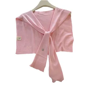 Pink knitted shawl capelet for women with navy collar style and tie-front fastener