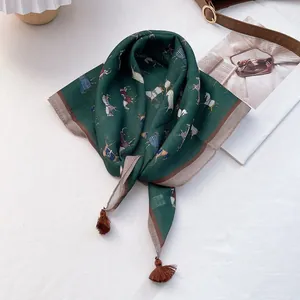 Detail of dark green equestrian print scarf with retro brown tassels on white background