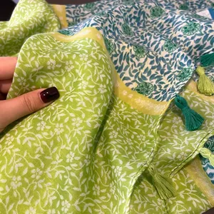 Détail d'une écharpe en lin à fleurs montrant les textures vert et bleu avec franges