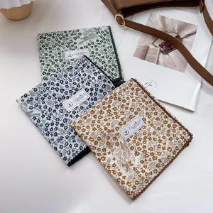 Set of three floral cotton handkerchiefs in green, blue and yellow with lace edges