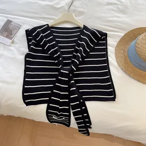 Détails de la texture du châle en maille à rayures noires et blanches avec col marin