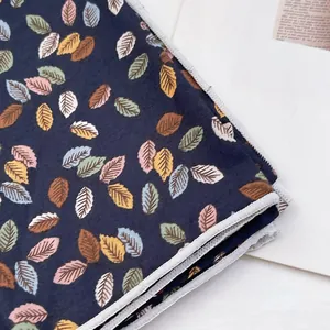 Gros plan du foulard en coton à imprimé feuilles colorées sur tissu bleu foncé