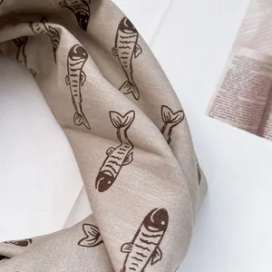 Detail eines Halstuchs aus Baumwollleinen mit handgezeichneten Fischmustern und Textur