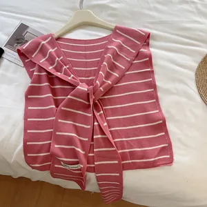 Gros plan du châle en tricot rayé rose et blanc avec un grand nœud décoratif
