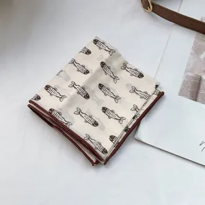 Detailansicht eines Baumwoll-Leinen-Halstuchs mit braunem Fischprint und Saum
