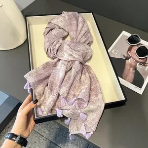 Lavender cotton-linen scarf with geometric gold stamping and tassel fringe displayed on a tray