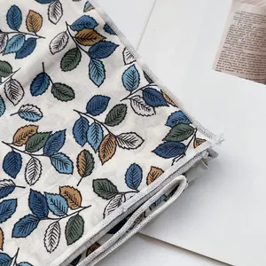 Détail de l'écharpe en coton avec motif floral et bordure avec surpiqûre soignée