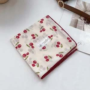 Macro view of cotton square scarf with red cherry print and burgundy lace edges