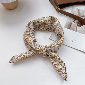 Detail of floral silk scarf with brown vine patterns and elegant lace crochet borders