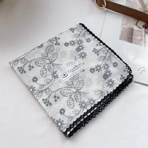 Detailed macro of 100% cotton floral handkerchief with intricate black lace borders