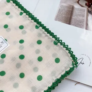 Detailed close-up of bohemian floral cotton headscarf with green scalloped edges
