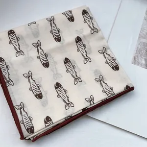 Nahaufnahme des Baumwoll-Leinen-Vierecktuches mit braunem Fischprint und feiner Kante