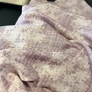 Close-up of light purple and cream fabric with gold foil accents and abstract patterns