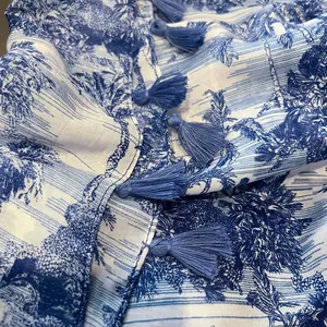 Close-up of blue tassel fringe and textured linen fabric with scenic landscape print