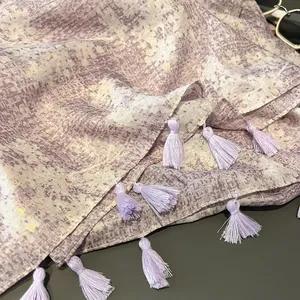 Lavender scarf with gold foil accents and tassel edges on a dark background