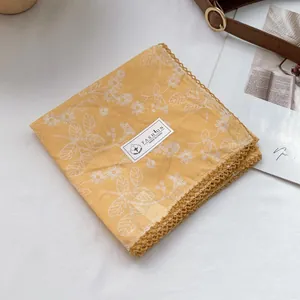 Detail of yellow cotton floral scarf with white daisy print and crochet lace edges