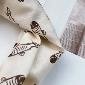 Detailansicht eines Leinen-Baumwoll-Vierecktuchs mit minimalistischen braunen Fischmustern