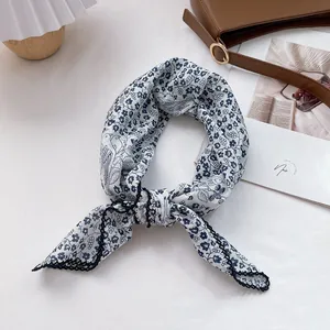 Detailed close-up of floral cotton scarf with lace edges on a stylish background