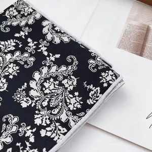 Vintage cotton paisley square scarf with white floral patterns on black fabric background