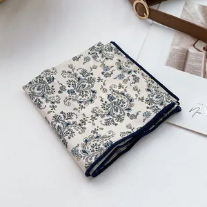 Macro shot of vintage floral cotton scarf with paisley pattern and navy blue hem