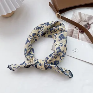 Detail of floral cotton square scarf in beige and navy blue with fine stitched edges