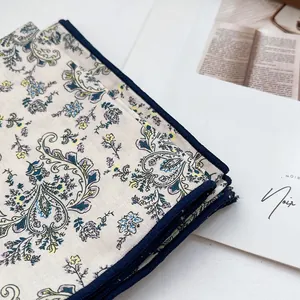 Close-up of vintage floral paisley pattern cotton square scarf with navy blue hemmed edges