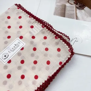 Detailed macro of a 100% cotton scarf with red polka dots and crochet lace edges
