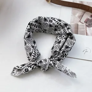 Détail d'un foulard à motifs géométriques noirs et blancs en tissu lisse