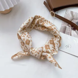 Close-up of beige cotton square scarf with brown floral patterns and lace trim detail
