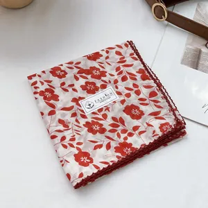 Detail of red floral cotton scarf showing handmade crochet lace trim and quality texture
