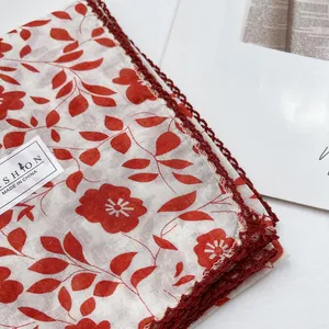 Detail of red floral cotton scarf with hand-crocheted lace edge and lightweight texture