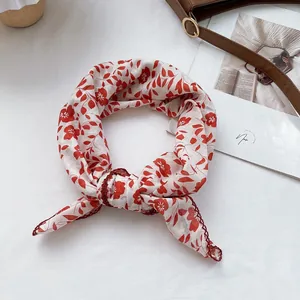 Close-up of red floral cotton square scarf featuring elegant lace edges and soft fabric