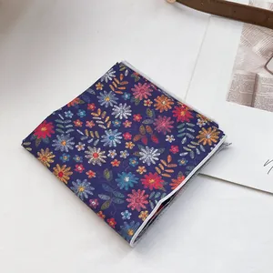Vue détaillée d'un foulard en coton à fleurs bleu foncé avec coutures de bordure grises
