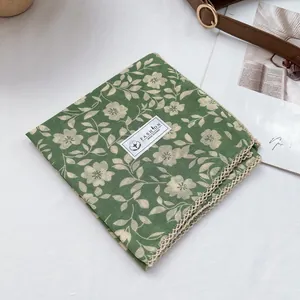 Detail of green floral 100% cotton scarf with delicate beige lace crochet edges