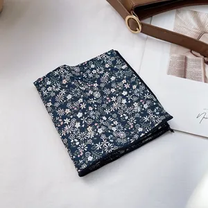 Detail of dark blue floral skinny scarf with daisy pattern and fine edge stitching