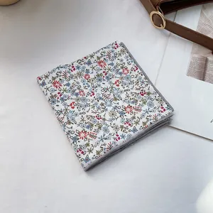 Detail of floral print scarf with refined gray piping edges on a lifestyle background