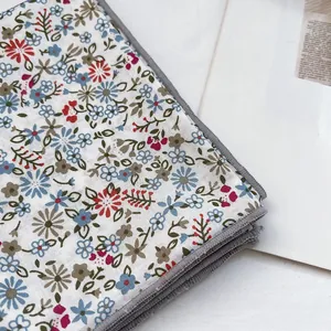 Detail of floral silk scarf with fine grey stitched edges and soft cotton texture