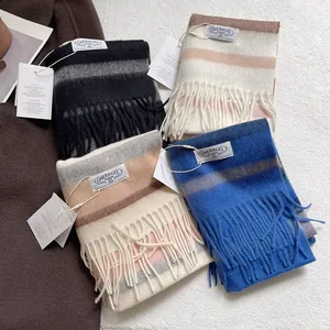 Assorted striped wool scarves with fringe in blue, grey, and pink for winter warmth