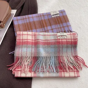 Classic 100% wool scarves with plaid pattern and fringe detail on white plush background