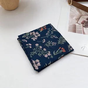 Detail eines floralen Kopftuchs mit feiner Naht und dunkelblauem Blumenmuster