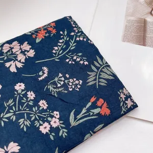 Detailansicht aus dunkelblauem Baumwoll-Leinen-Stoff mit rosa Blumen für das Kopftuch