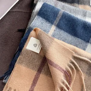 Detailed close-up of 100% wool plaid scarf texture with handmade tassels