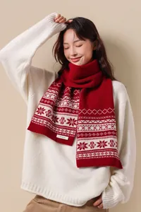 Detail showing the 100% wool label on a red Fair Isle knit scarf with snowflake patterns