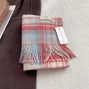 Classic 100% wool plaid scarf with fringes in red and blue on a soft winter carpet
