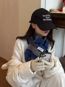 Close-up of blue striped wool scarf paired with a black baseball cap and white puffer jacket