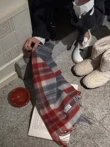 Detailed close-up of wool plaid scarf texture with long fringe on stone steps