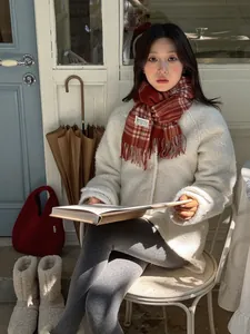 Close-up of red and brown plaid wool scarf styled with a cozy cream fleece jacket