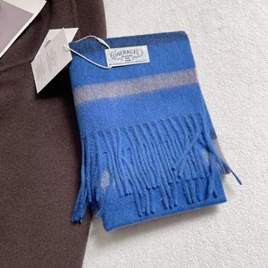 Cozy blue striped wool scarf with fringe and 100% wool label on a winter texture background